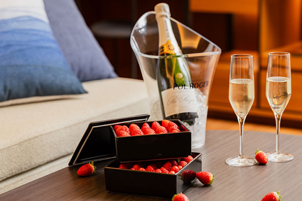 テーブルに並べられたシャンパン1本とフレッシュ苺の写真です。