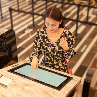 Photo: Woman operating a self-service check-in machine