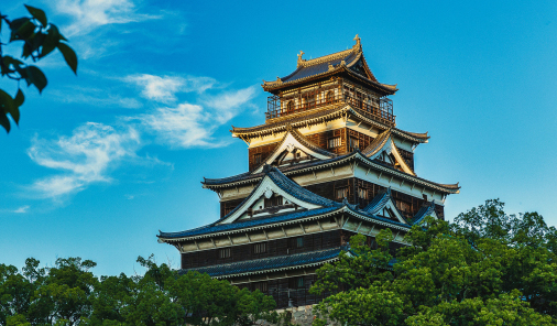 写真：青い空と太陽に照らされ、緑溢れる自然の中に建つ広島城